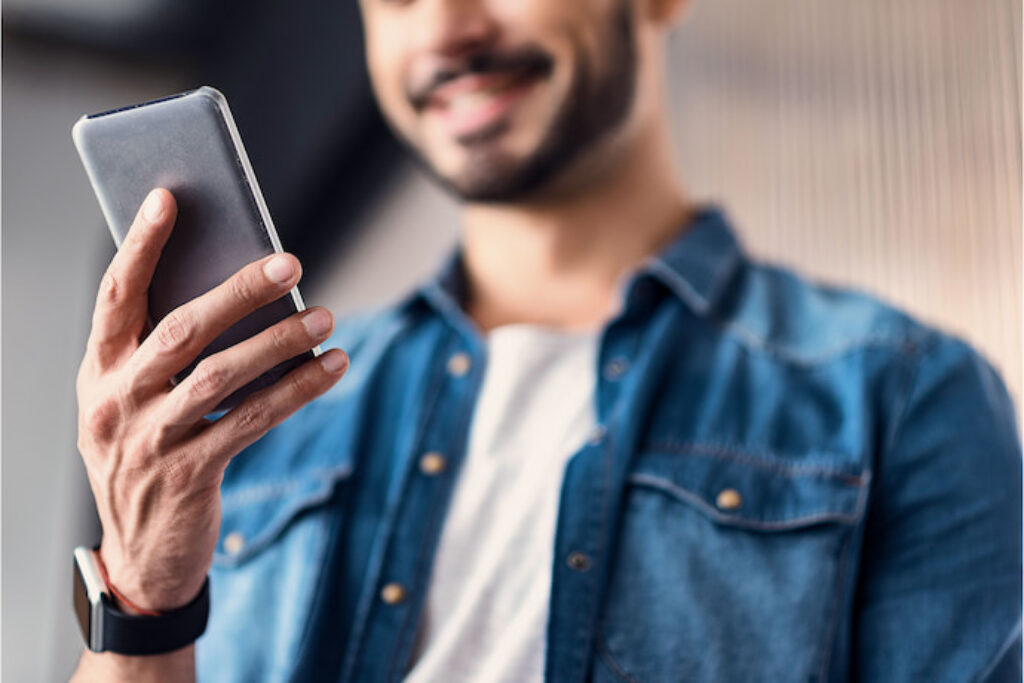 Homem sorrindo para o celular