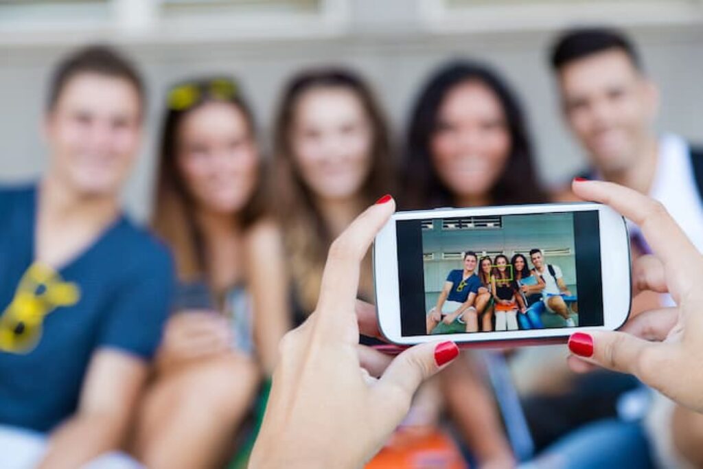 grupo de amigos tirando fotos com um celular de câmera boa
