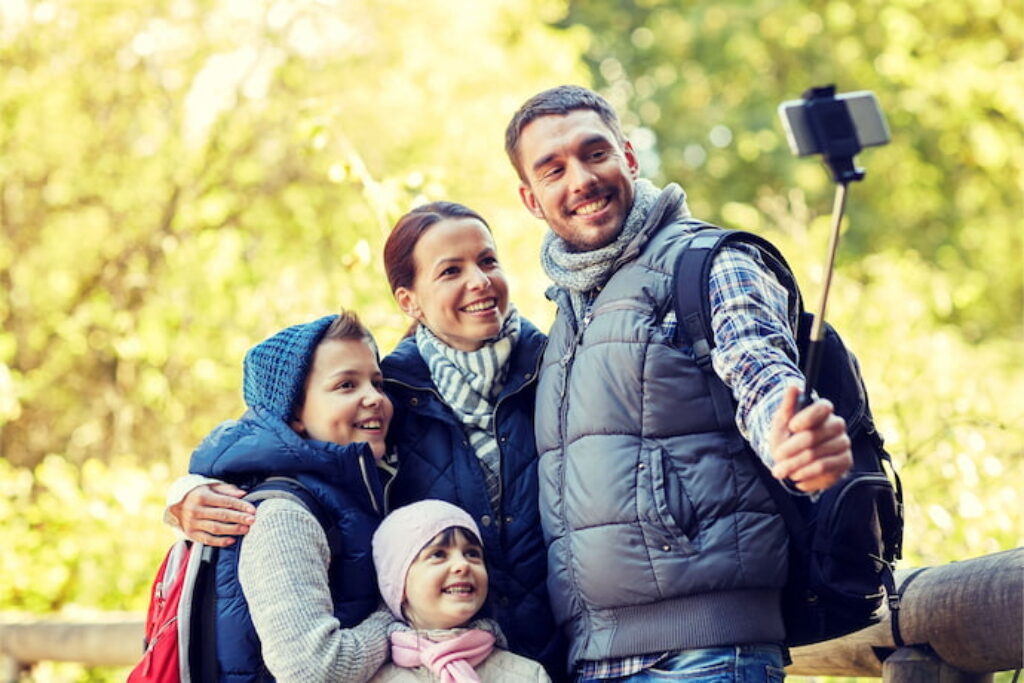 Família tirando foto com pau de selfie