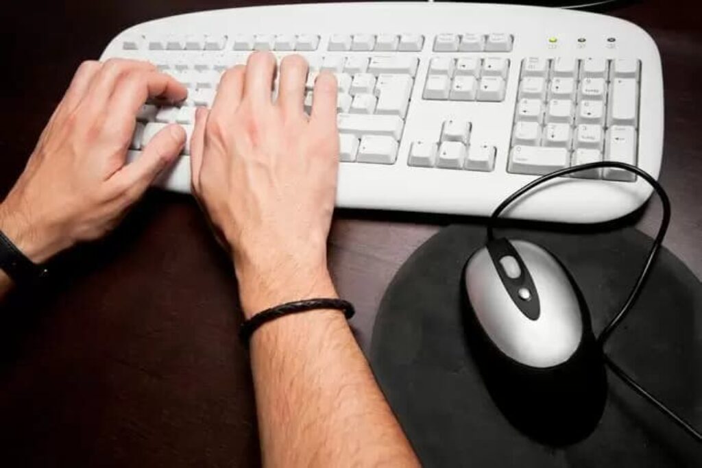 Homem usando teclado e mouse de computador