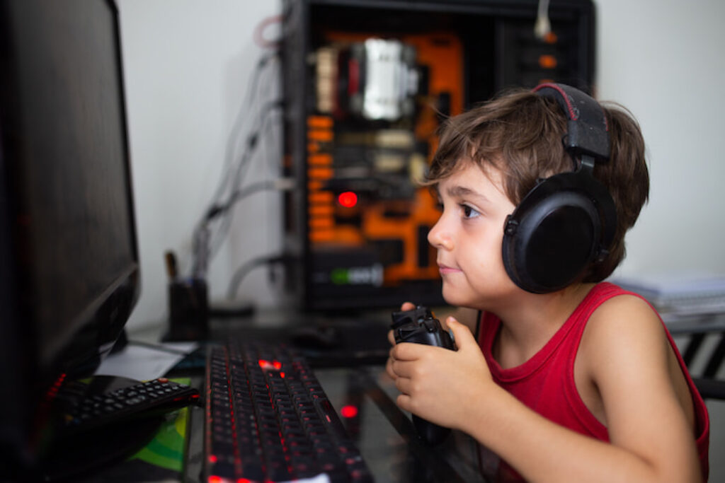 Criança jogando no PC com headset
