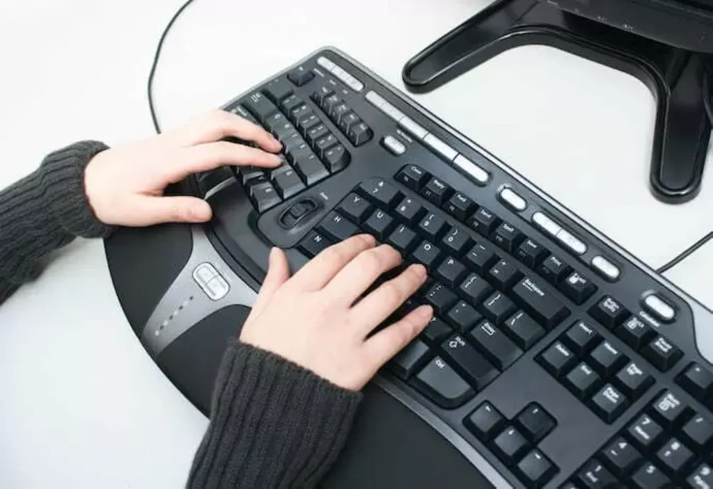 mulher usando teclado ergonômico