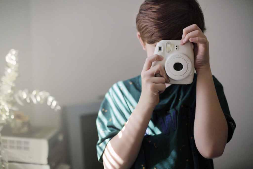 Criança tirando foto com a Polaroid
