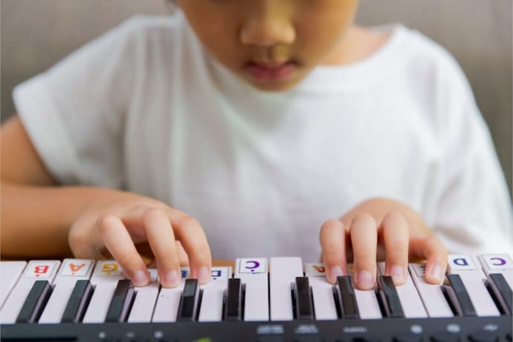 Criança pequena usando teclado infantil